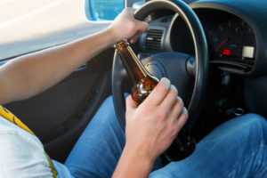 Car driver holding a bottle of beer